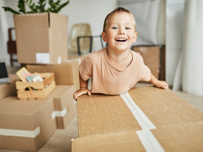 Cute Boy Moving Boxes in New Home